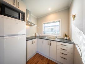 A kitchen with a refrigerator and sink at Dusky Hunting Unit - Te Anau Holiday Home in Te Anau
