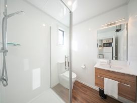 A bathroom with a shower, toilet, and sink at Dusky Hunting Unit - Te Anau Holiday Home in Te Anau