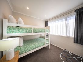 A bedroom with bunk bed and lamp at Dusky Hunting Unit - Te Anau Holiday Home