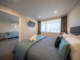 A bedroom with a bed and window at Dusky Hunting Unit - Te Anau Holiday Home in Te Anau