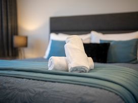A bedroom with towels on a bed at Dusky Hunting Unit - Te Anau Holiday Home Te Anau