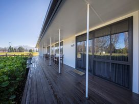 A deck with chairs and a table at Dusky Hunting Unit - Te Anau Holiday Home Te Anau