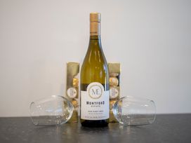 A wine bottle with glasses and a box of chocolates at Fishing - Te Anau Holiday Home Te Anau