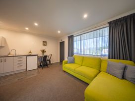 A living room with a kitchenette and seating at Fishing - Te Anau Holiday Home in Te Anau