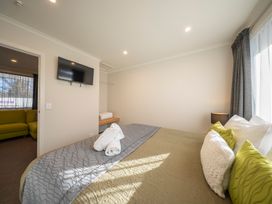 A bedroom with a bed and television at Fishing - Te Anau Holiday Home in Te Anau