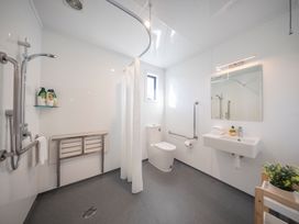 A bathroom with a shower, toilet, and sink at Fishing - Te Anau Holiday Home in Te Anau