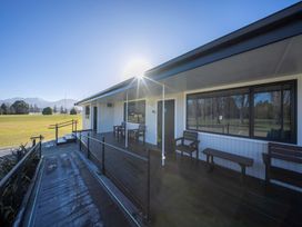 An outdoor deck area with table and chairs at Fishing - Te Anau Holiday Home in Te Anau