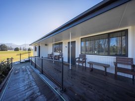 A house exterior with a deck and chairs at Fishing - Te Anau Holiday Home in Te Anau