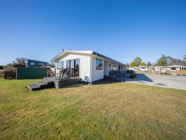 A house with a deck and chairs in the yard at Dusky Rugby Unit - Te Anau Holiday Home Te Anau