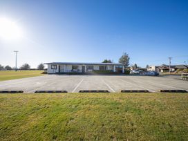 A building with parking lot and grass area at Dusky Rugby Unit - Te Anau Holiday Home Te Anau