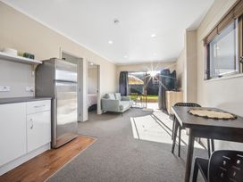 A kitchen with fridge, table, and couch at Matakana Holiday Home Warkworth