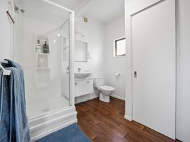 A bathroom with a shower, toilet, and sink at Matakana Holiday Home in Warkworth