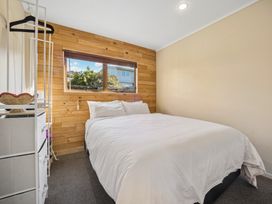 A bedroom with a bed and window at Matakana Holiday Home in Warkworth