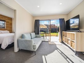 A living room with couch and television at Matakana Holiday Home in Warkworth