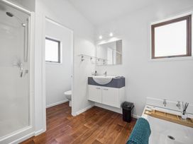 A bathroom with a shower, toilet, and sink at Matakana Holiday Home in Warkworth