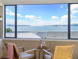 A living room with a view of the water at Matakana Holiday Home in Warkworth