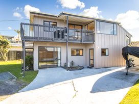 An outdoor view of a house with a balcony and boat at Matakana Holiday Home in Warkworth