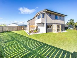 A house with a patio and grass at Matakana Holiday Home in Warkworth