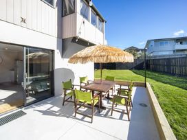 An outdoor seating area with a table and chairs at Matakana Holiday Home in Warkworth