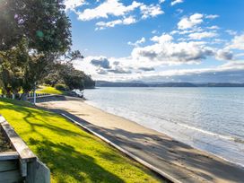 A beach with trees and a pathway at Matakana Holiday Home in Warkworth
