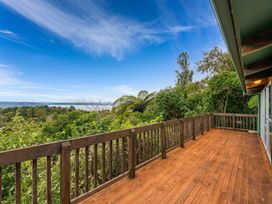 A deck overlooking trees and water at Hauraki Haven - Lake Taupo Holiday Home Pukawa