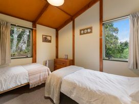 A bedroom with two single beds and windows at Hauraki Haven - Lake Taupo Holiday Home Pukawa