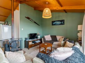 A living room with a fireplace and television at Hauraki Haven - Lake Taupo Holiday Home Pukawa