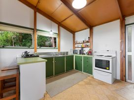 A kitchen with stove and microwave at Hauraki Haven - Lake Taupo Holiday Home in Pukawa
