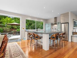 A kitchen with an island and bar stools at Langs Beach Holiday Home Langs Beach