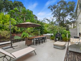 An outdoor area with a patio, table, chairs, and a barbecue grill at Langs Beach Holiday Home in Langs Beach