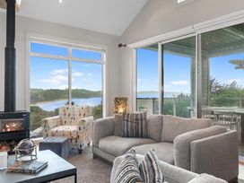A living room with a sofa and armchair at Langs Beach Holiday Home in Langs Beach