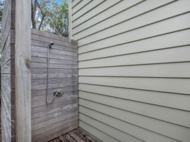 An outdoor shower with wooden walls at Langs Beach Holiday Home in Langs Beach