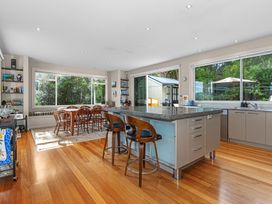 A kitchen with a dining table and bar stools at Langs Beach Holiday Home in Langs Beach
