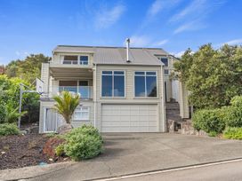 A house with a garage and balcony at Langs Beach Holiday Home in Langs Beach