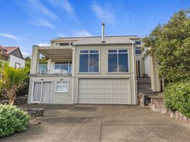 A house with a garage and balcony at Langs Beach Holiday Home in Langs Beach
