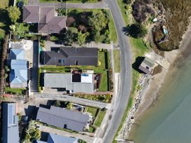 An aerial view of residential houses and a shoreline at Roy-Al Retreat - Riwaka