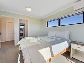 A bedroom with a bed and nightstand at Roy-Al Retreat - Riwaka Holiday Home Riwaka
