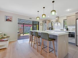 A kitchen with an island and stools at Roy-Al Retreat - Riwaka Holiday Home, Riwaka