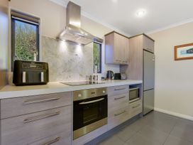 A kitchen with an oven, refrigerator, microwave and air fryer at Roy-Al Retreat - Riwaka Holiday Home Riwaka