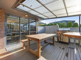 An outdoor area with a wooden table and barbecue at Roy-Al Retreat - Riwaka Holiday Home Riwaka