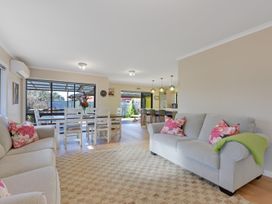 A living room with a sofa and dining area at Roy-Al Retreat - Riwaka Holiday Home Riwaka