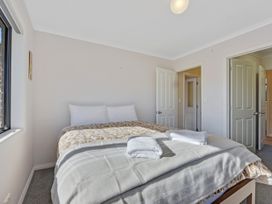 A bedroom with a bed and towels at Roy-Al Retreat - Riwaka Holiday Home Riwaka