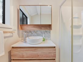 A bathroom with a sink and mirror at Roy-Al Retreat - Riwaka Holiday Home Riwaka