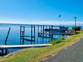 A dock and boat on water at Roy-Al Retreat - Riwaka Holiday Home Riwaka