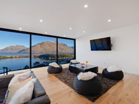 A living room with a view of mountains and lake at Alpine Haven - Queenstown Villa in Queenstown
