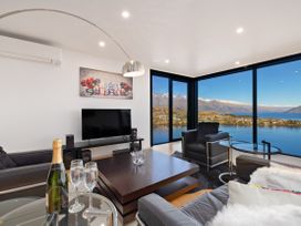 A living room with a television, sofa and coffee table at Alpine Haven - Queenstown Villa in Queenstown