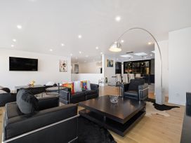 A living room with a sofa and coffee table at Alpine Haven - Queenstown Villa in Queenstown