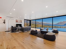 A living room with a television and sofa at Alpine Haven - Queenstown Villa in Queenstown