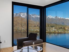 A living room with a view of mountains and water at Alpine Haven - Queenstown Villa, Queenstown