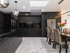 A kitchen with a long table and chairs at Alpine Haven - Queenstown Villa, Queenstown
